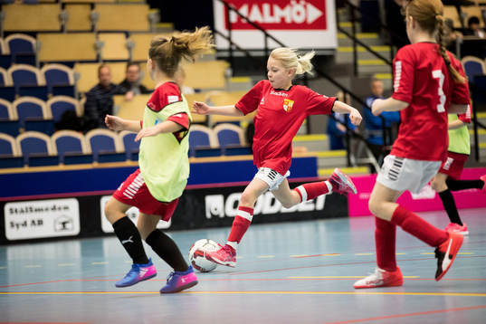 En flicka driver med bollen