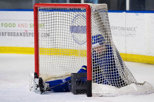 Rasmus Dahlin sitter inuti ett mål och plockar ihop puckar