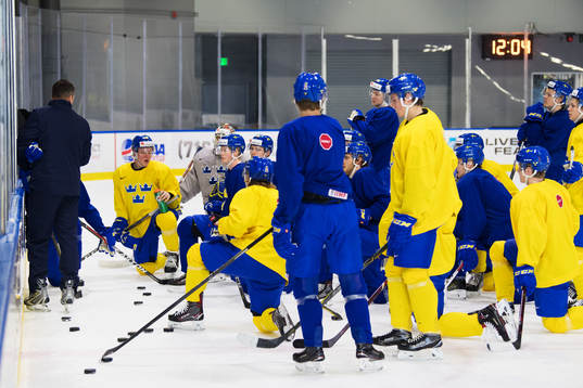 Spelare lyssnar på förbundskapten Tomas Montén som har