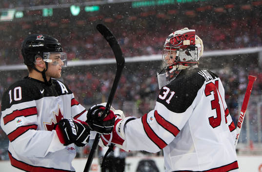 Kanadas Kale Clague och målvakt Carter Hart jublar