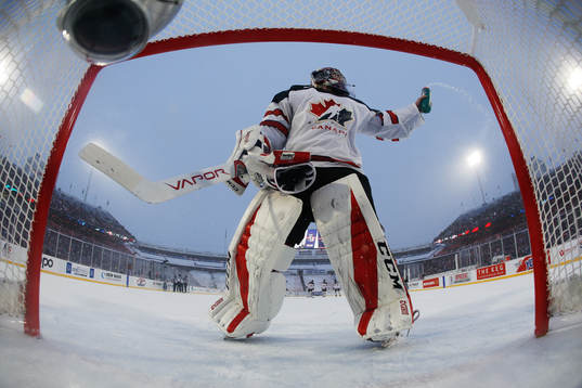 Kanadas målvakt Carter Hart sprutar ut vatten ur sin