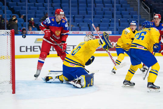 Pucken går i ribban bakom Sveriges målvakt Filip