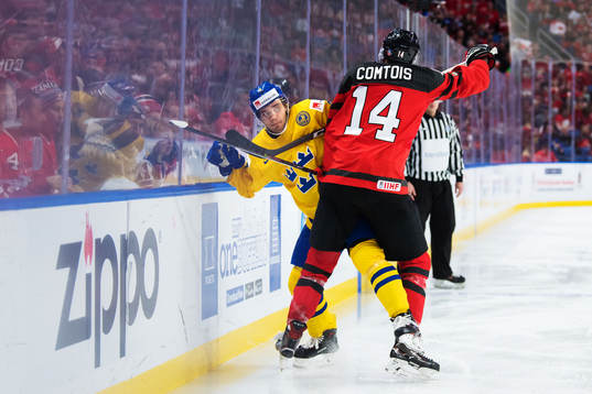Sveriges Timothy Liljegren tacklas av Kanadas Maxime Comtois