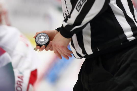 Domare håller i pucken innan tekning
