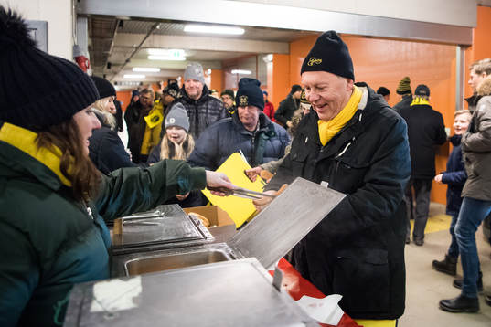 En glad supportar äter korv med bröd