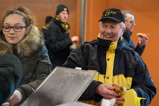 En glad supportar äter korv med bröd