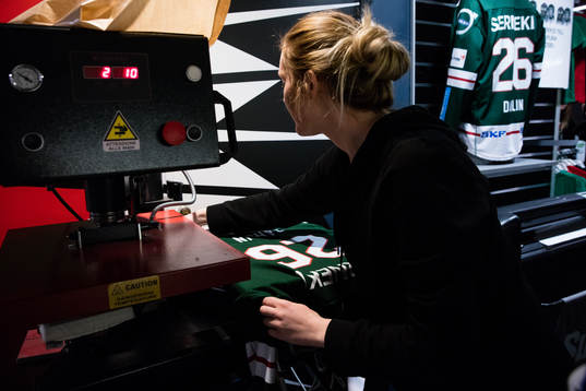 En tjej trycker upp en Frölunda tröja med Rasmus Dahlins