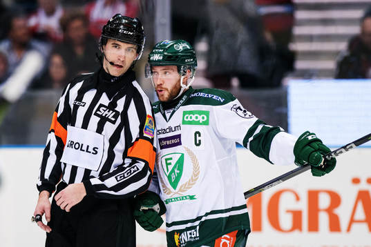 Domare Linus Öhlund diskuterar med Färjestads Linus