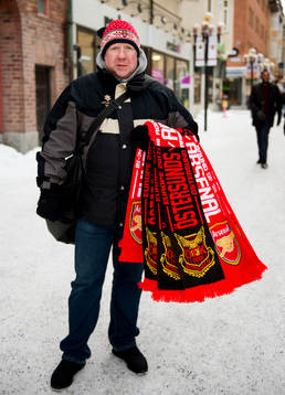 En försäljare säljer halsdukar innan fotbollsmatchen i