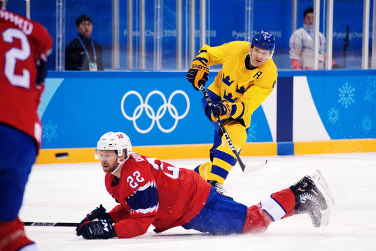Staffan Kronwall of Sweden shoots while Martin Røymark of