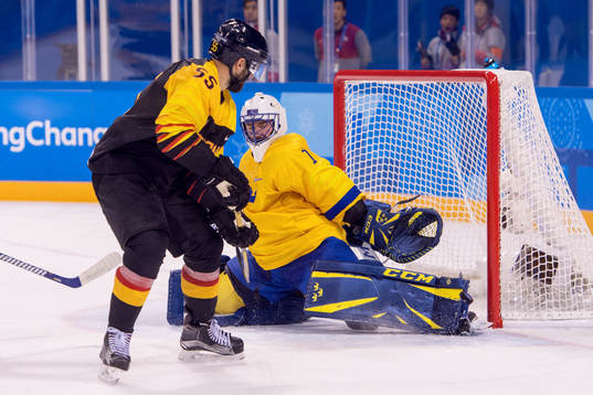 Goaltender Jhonas Enroth of Sweden and Felix Schutz of