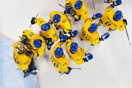 The players of Sweden gather around goaltender Viktor Fasth
