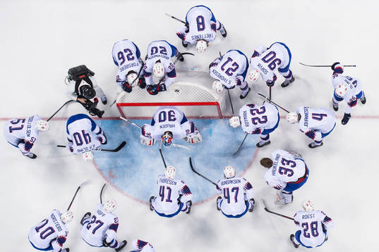 The Norwegian team gathers around goaltender Lars Haugen of