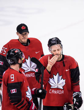 Goaltender Justin Peters and Andrew Ebbett of Canada looks