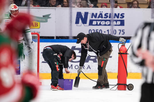 Vaktmästarna fixar isen vid Rögles mål i ishockeymatchen
