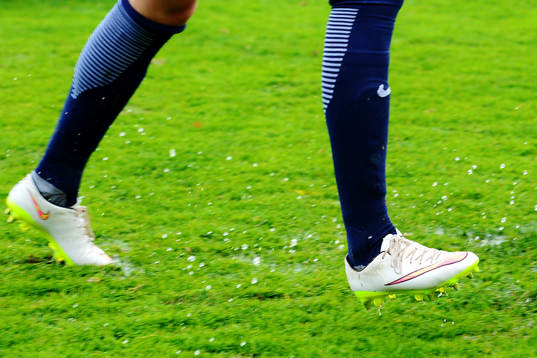 Norges spelare springer på en blöt fotbollsplan