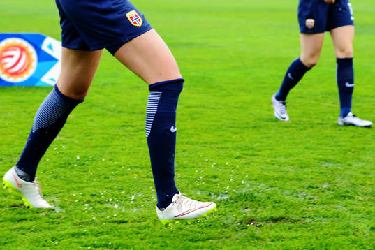 Norges spelare springer på en blöt fotbollsplan