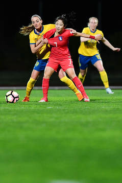 Sveriges Kosovare Asllani i kamp om bollen med Sydkoreas