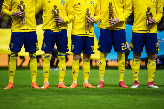 Sveriges spelare håller i statyer i en kampanj mot mobbning