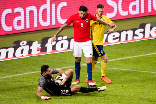 Chiles målvakt Johnny Herrera räddar skott framför