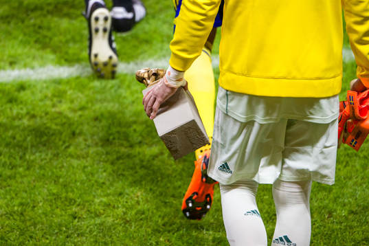 Spelare med en staty före träningslandskampen i fotboll