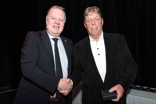 Hasse Olofsson tar emot en medalj för sina insatser för
