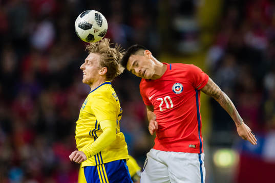 Chiles Charles Aranguiz i kamp om bollen med Sveriges Emil