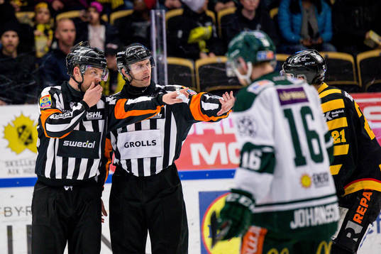 Domare Mikael Nord och domare Linus Öhlund motar bort