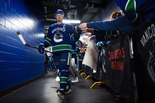 Vancouvers Henrik Sedin på väg ut till ishockeymatchen i