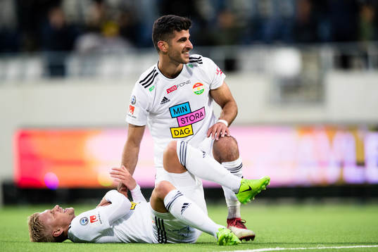 Dalkurds Rewan Amin omfamnar en liggande Simon Strand