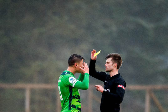 Alexander Dang of Nest-Sotra is shown a yellow card by