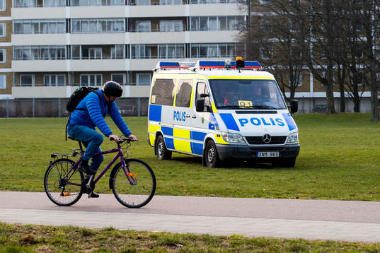 En cyklist passerar en polisbil