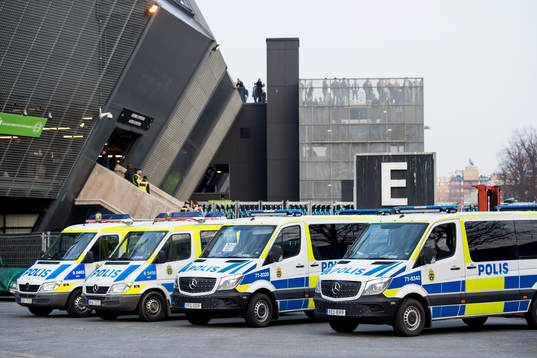 Polisbilar står uppställda vid ingången bortastå