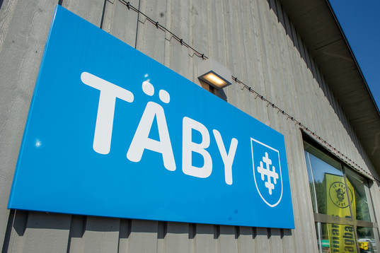 En skylt med Täbys logotyp före en fotbollsmatch i