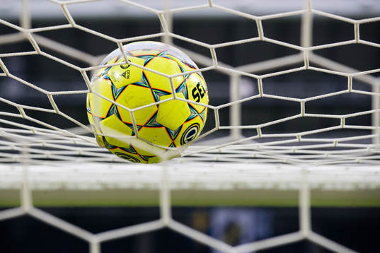 En fotboll ligger på nättaket av ett fotbollsmål innan