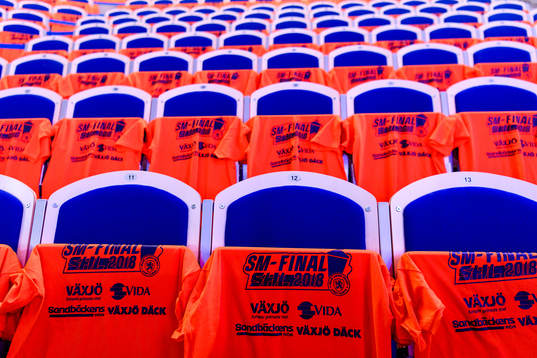 Orangea t-shirts hänger på alla stolar före final 1 i