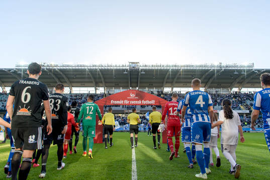 Spelarna går in på arenan innan fotbollsmatchen i
