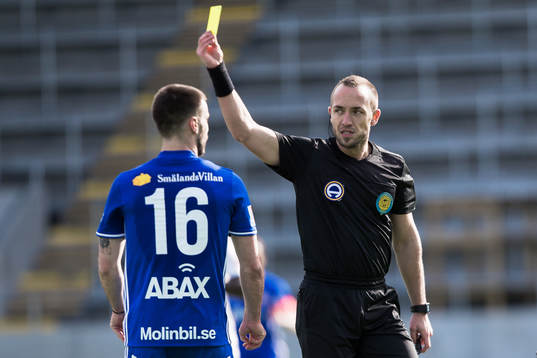domare Kaspar Sjöberg delar ut ett gult kort till