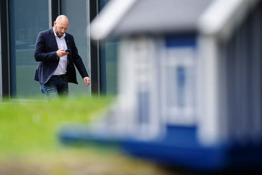 Klubbdirektör Max Markusson tittar i telefonen i samband