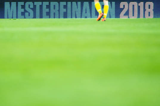 A Lillestrøm player walks in front of an advertising board
