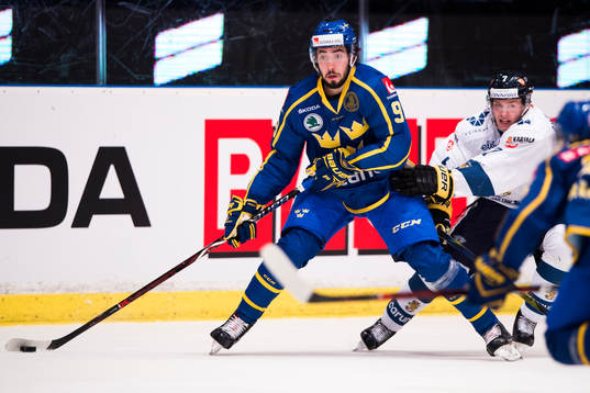 Sveriges Mika Zibanejad med pucken tätt bevakad av