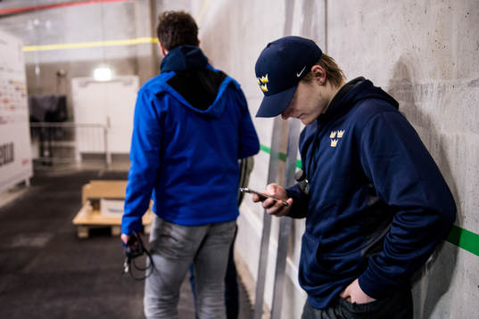 Sveriges Lias Andersson tittar i sin telefon utanför mixed