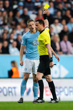 Malmö FFs Mattias Svanberg får en varning av domare