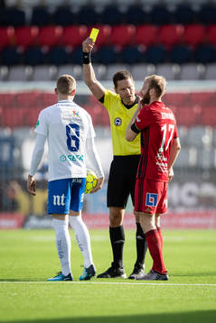domaren Martin Strömbergsson utdelar ett gult kort till