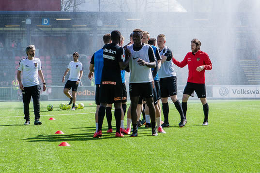 Brommapojkarnas spelare värmer upp innan fotbollsmatchen i