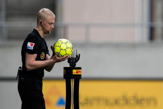 Domare Adam Ladebäck plockar upp matchbollen innan