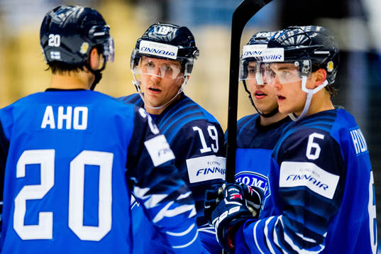 Sebastian Aho talks to teammates Veli-Matti Savinainen,