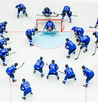Players of Finland gather around goaltender Harri Sateri of