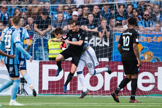 Malmö FFs Eric Larsson tacklar Djurgårdens målvakt