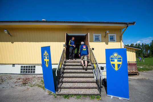 Två funktionärer vid en ingång med två vepor